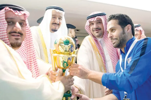 خادم الحرمين يتوج قائد فريق الهلال ياسر القحطاني بكأس الملك ويبدو رئيس النادي الأمير نواف بن سعد (واس)