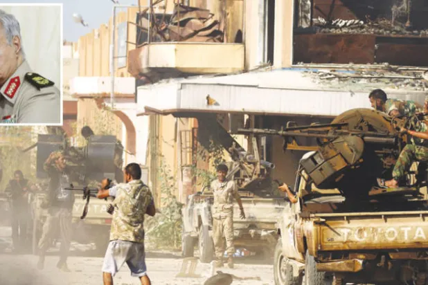 أفراد من الجيش الوطني الليبي يشتبكون مع عناصر متشددة في أحد أسواق بنغازي في مايو الماضي (غيتي) - المشير خليفة حفتر (رويترز)