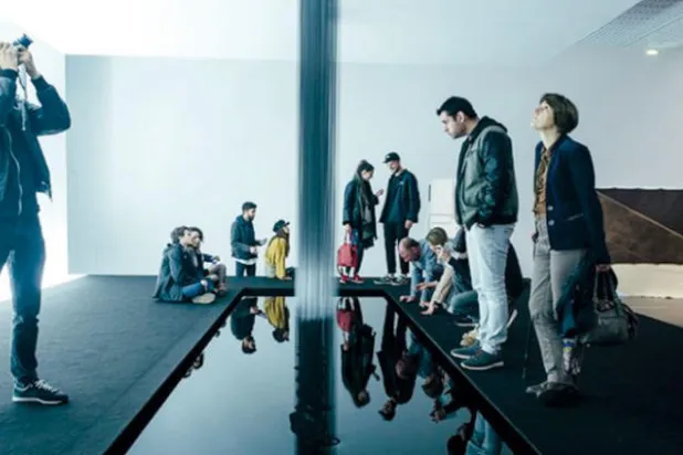 زوار المعرض يتأملون قطعة كوهاي ناوا التي يتساقط منها «شتاء الزيت» من دون التناثر (نيويورك تايمز)