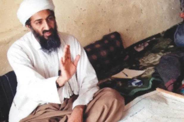 بن لادن وأمامه خريطة في مخبئه بأبوت آباد قبل الغارة الأميركية عليه («الشرق الأوسط»)