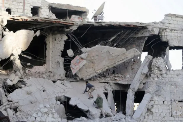 عناصر من الجيش الليبي الوطني يتسلقون ركام بناء مهدم بفعل الاشتباكات مع المسلحين في خريبيش أحد أحياء بنغازي (رويترز)