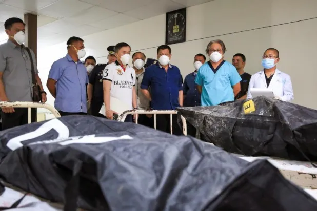 (الرئيس الفلبيني رودريغو دوتيرتي أمام جثث ضحايا الحريق التجاري (إ.ب.أ