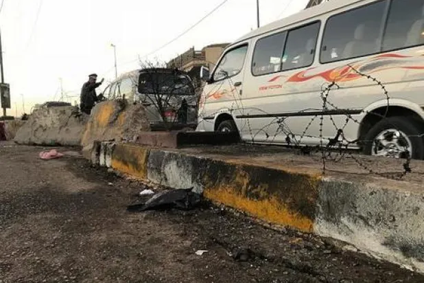 أحد رجال الشرطة العراقية يوجه حركة المرور بأعقاب تفجير انتحاري في بغداد (آ.ب)