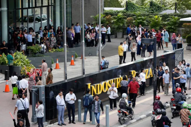 موظفون يخلون المباني في جاكرتا (رويترز)