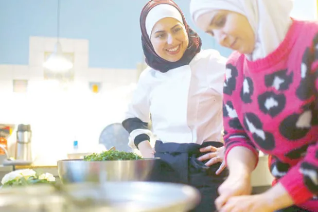 السورية ملكة جزماتي أثناء عملها في أحد المقاهي ببرلين (رويترز)