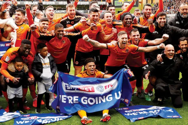 لاعبو وولفرهامبتون وجهازهم الفني يحتفلون بالصعود إلى الدوري الممتاز الإنجليزي (رويترز)