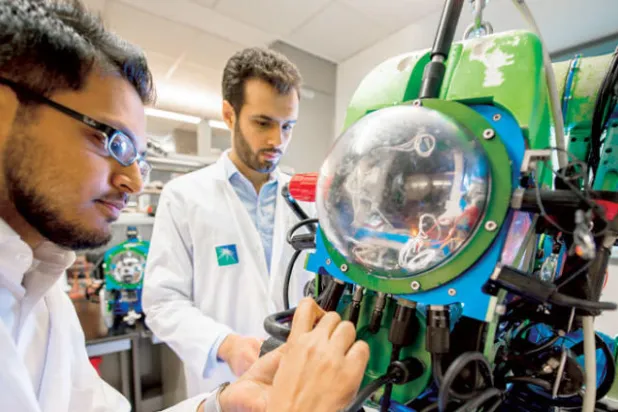 مهندسان يجريان عملية صيانة لروبوت المياه الضحلة