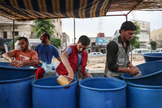 السوريون يبيعون منتجاتهم في إحدى الأسواق (إ.ب.أ) 