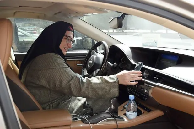 ريم فرحات خلال استعدادها لأول رحلة توصيل على سيارتها (أ.ف.ب)