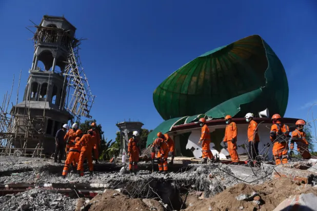 عمال الإنقاذ يبحثون عن ضحايا زلزال ضرب جزيرة لومبوك الإندونيسية (رويترز)