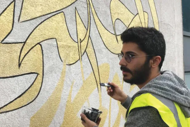 غالب هويلة يخطّ جملة للشّاعر الرّاحل محمود درويش («الشرق الأوسط»)