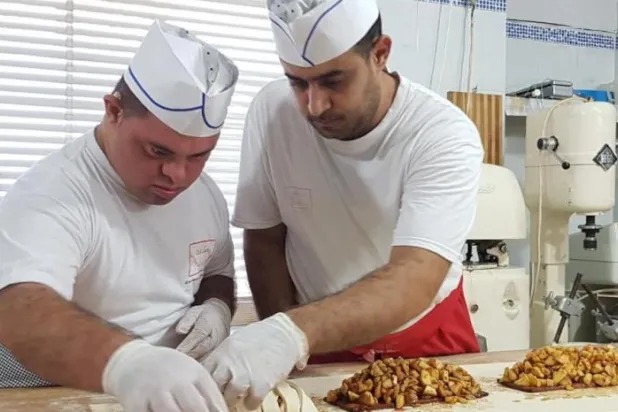 موظفون من ذوي الاحتياجات الخاصة يحضرون الخبز والحلويات (جمعية مصان) 