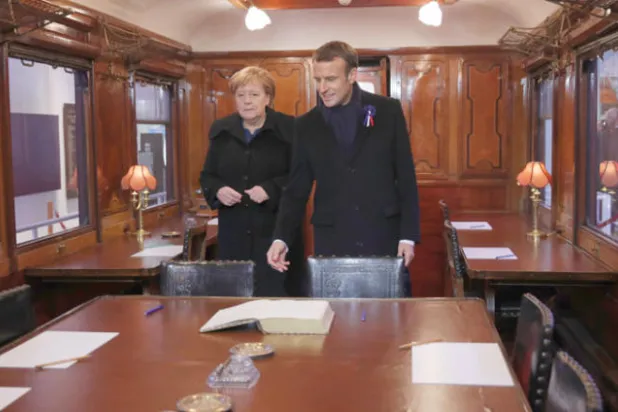 الرئيس ماكرون مع المستشارة ميركل أمس يوقّعان كتاب الزوار في العربة التاريخية التي تم فيها توقيع اتفاق الهدنة الذي أنهى الحرب العالمية الأولى في 11 نوفمبر 1918 (إ.ب.أ)