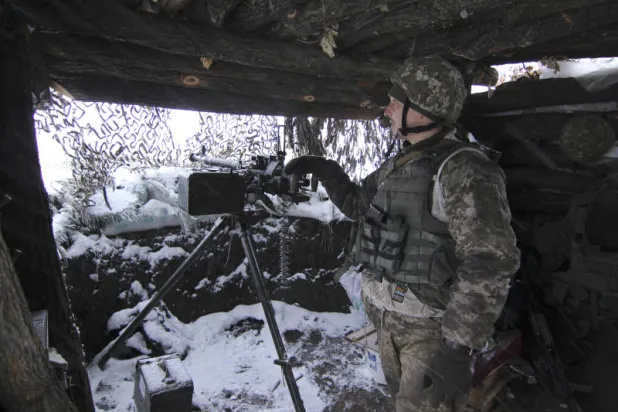 جندي أوكراني يقف في الخدمة مع مدفع رشاش ثقيل بمكان مجهول شرق أوكرانيا (أ.ف.ب)
