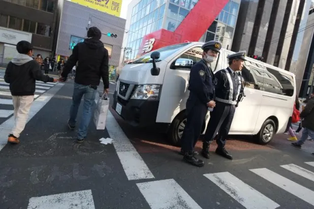 الشرطة اليابانية تقف عند مدخل شارع تاكيشيتا الذي وقع به حادث الدهس في وقت مبكر صباح اليوم (أ.ف.ب)