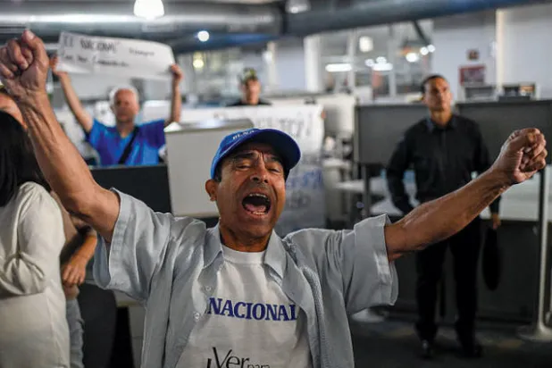 أحد موظفي الصحيفة في ديسمبر 2018 يناهض قرار إلغاء النسخة الورقية جراء ضغوط الحكومة (غيتي)