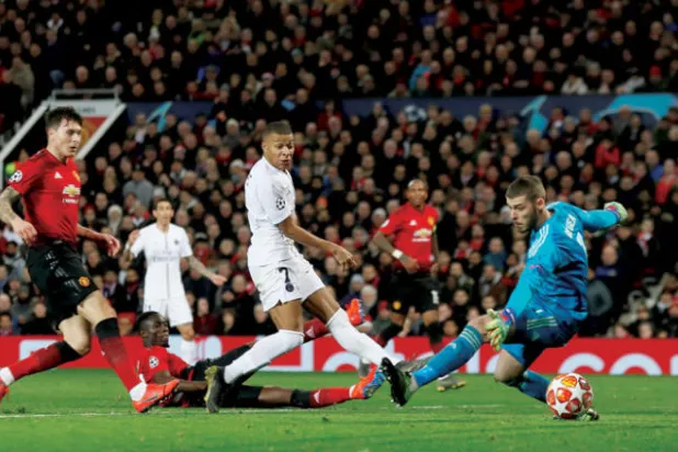 مبابي (في الوسط) يسجل في مرمى دي خيا حارس يونايتد ليعزز انتصار باريس سان جيرمان (رويترز)