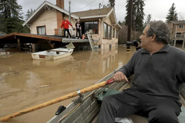 رجل يحاول التنقل في المدينة باستخدام قارب (أ.ب)