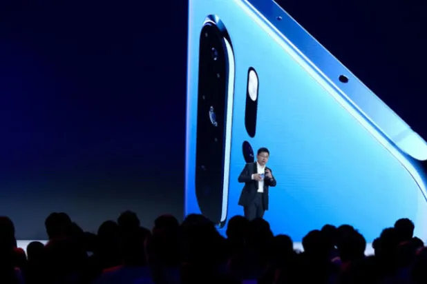 ريتشارد يو المدير التنفيذي بقسم المنتجات الاستهلاكية لشركة «هواوي» الصينية وتبدو في الخلفية صورة ضخمة لهاتف «بي 30» الذكي الجديد (أ.ف.ب)