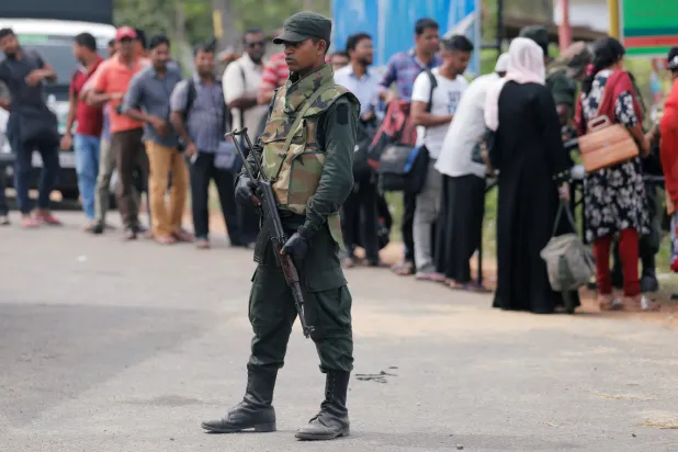 عنصر أمن قرب نقطة تفتيش في سريلانكا (رويترز)