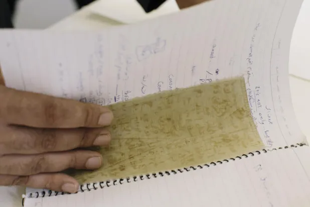 المعتقل منصور عمري يعرض قطعة قماش كتب عليها معتقلون أسماءهم بالدم وهربوها من السجن (خدمة نيويورك تايمز)