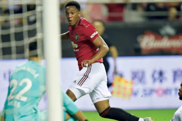 مارسيال نجم يونايتد (يسار) يسجل هدف فريقه الأول في مرمى توتنهام (أ.ف.ب)