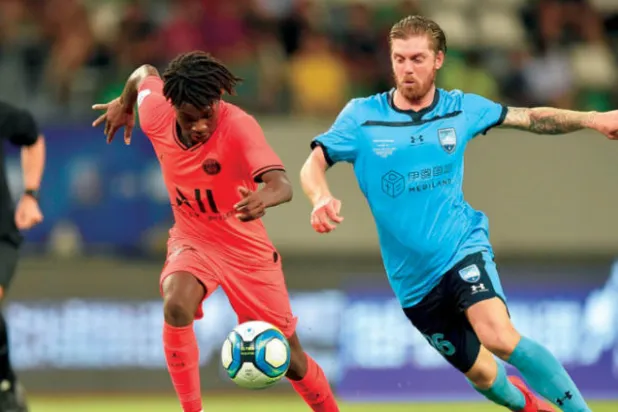 آرثر لاعب سان جيرمان (يسار) في سباق على الكرة مع باراتان لاعب سيدني (أ.ف.ب)