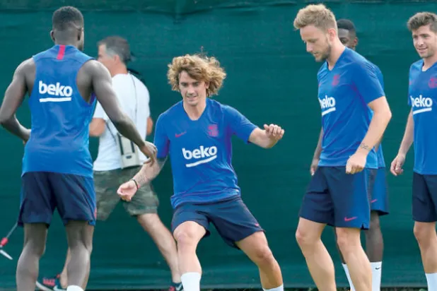غريزمان الذي ينتظر أن يملأ فراغ ميسي يمرر الكرة وسط زملائه خلال تدريبات برشلونة (أ.ف.ب)