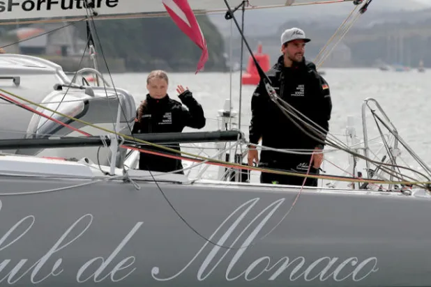 غريتا ثنبرغ الفتاة السويدية الناشطة في المجال البيئي مع القبطان الألماني بوريس هيرمان أثناء استعدادها للإبحار يوم الأربعاء الماضي عبر المحيط الأطلسي بدلاً من السفر جواً (أ.ف.ب)