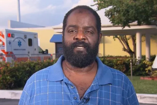 رجل أعمى يحمل ابنه المصاب بالشلل لإنقاذه من الإعصار «دوريان»