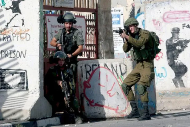 ایک اسرائیلی فوجی کو بدھ کے روز غزہ پر بمباری کے خلاف بیت اللحم کے مظاہرہ کی طرف اپنے ہتھیار سے نشانہ بناتے ہوئے دیکھا جا سکتا ہے