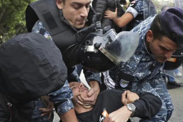 شرطة مكافحة الشغب تشتبك مع متظاهرين يسدون طريقاً في بيروت (أ.ب)