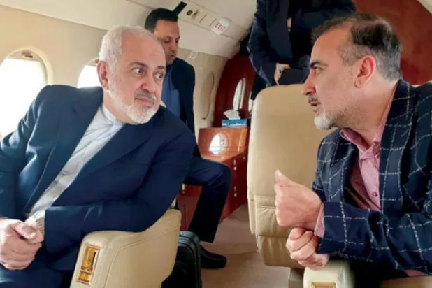 İran Dışişleri Bakanı Cevat Zarif, dün, uçakta İranlı bilim adamı Mesut Süleymani ile konuşurken (AFP)