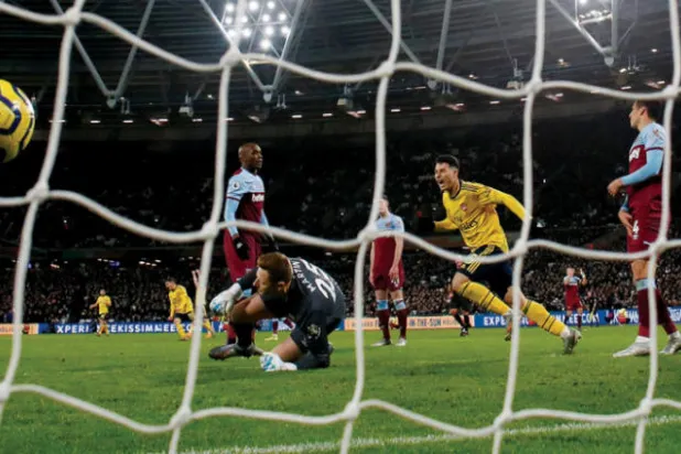 لاعب آرسنال الشاب مارتينيلي (في الوسط) يراقب تسديدة وهي تسكن شباك وستهام (رويترز)