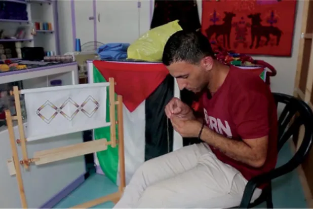 سليمان خلال عمله في التطريز داخل معرضه (الشرق الأوسط)
