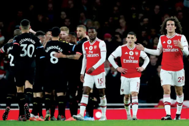 لاعبو ارسنال يراقبون في حسرة احتفالات لاعبي سيتي بالفوز عليهم (رويترز)