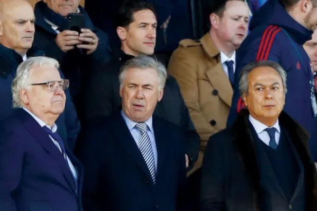 أنشيلوتي بين موشيري مالك إيفرتون والرئيس التنفيذي كينرايت يراقبون الفريق خلال مواجهة آرسنال (أ.ب.أ)