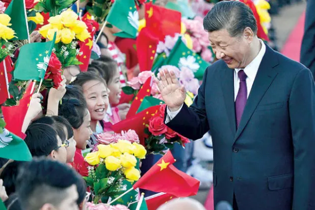 الرئيس الصيني يحيّي أطفالا لدى وصوله إلى مطار ماكاو في الذكرى العشرين لاستلامها من البرتغال في 18 ديسمبر (أ.ف.ب)