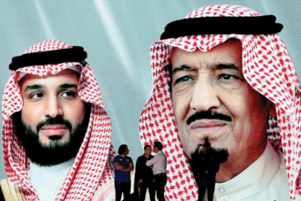 صورة الملك سلمان وولي العهد على شاشة العرض في قرية داكار (أ.ب)