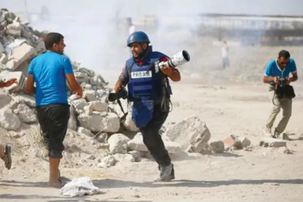 صحافي فلسطيني يهرب من القنابل الغازية في الميدان