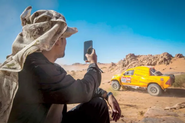 مشجع يلتقط صورة بجواله لمجريات السباق (الشرق الأوسط)