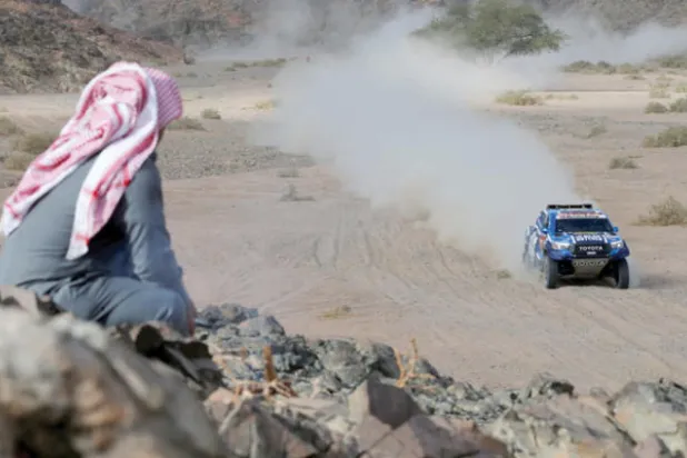 مشجع يتابع منافسات رالي داكار من على أحد المرتفعات (رويترز)