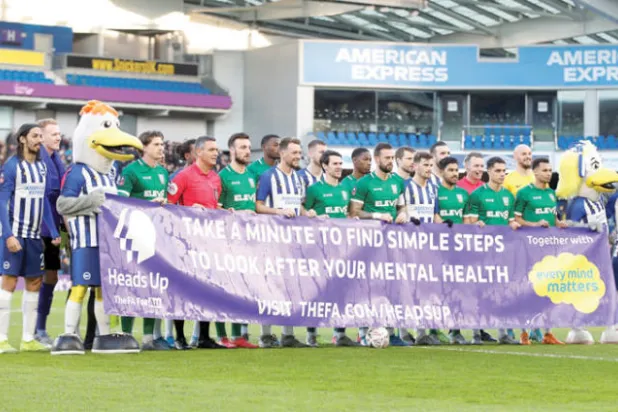 لاعبو برايتون وشيفيلد ونزداي يحملون لافتة تشجع على التفكير في الصحة الذهنية (رويترز)