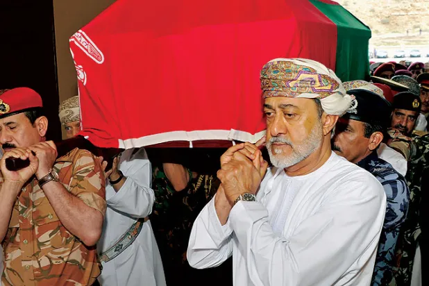 السلطان هيثم بن طارق يحمل جثمان السلطان الراحل قابوس بن سعيد خلال مراسم التشييع في مسقط أمس (رويترز)