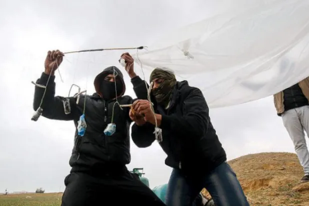 جنوبی غزہ کے شہر رفح میں فلسطینی نوجوانوں کو اسرائیل کی طرف چھوڑنے والے فائر بیلون کو تیار کرتے ہوئے دیکھا جا سکتا ہے (اے ایف پی)