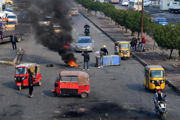 متظاهرون يقطعون طريقا في وسط العاصمة بغداد (إ.ب.أ) 