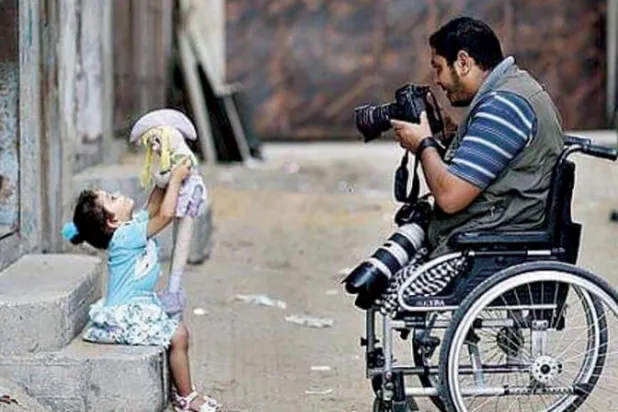 الصحافي مؤمن قريقع خلال التقاطه صوراً للحياة اليومية في غزة