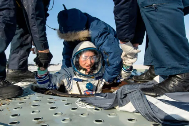 رائدة الفضاء كريستينا كوك لحظة خروجها من سفينة الفضاء بعد هبوطها للأرض ( أ.ف.ب)