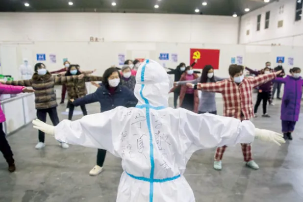 ممرض يقود تمارين لمصابين بفيروس «كورونا» في أحد مستشفيات ووهان (أ.ف.ب)