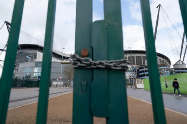 بوابات ملعب مانشستر سيتي المغلقة تنطق مثل مثيلاتها في الأندية الأخرى بأزمة الكرة الإنجليزية (أ.ب)